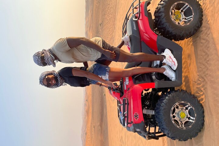 Experience the vast desert as you ride an ATV across golden dunes soaking in the stunning views and the thrill of adventure perfect for those seeking memorable desert exploration.